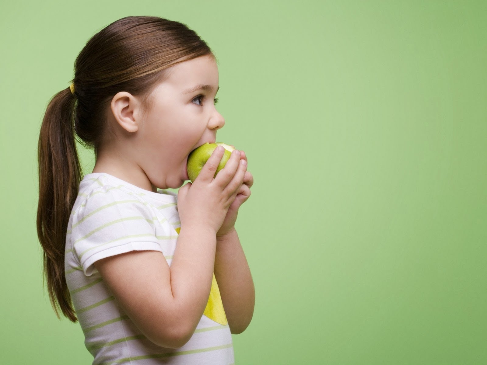 She eats apples. Девочка ест яблоко. Ребенок ест яблоко. Ребенок кусает яблоко. Девочка ест яблоко картинка.